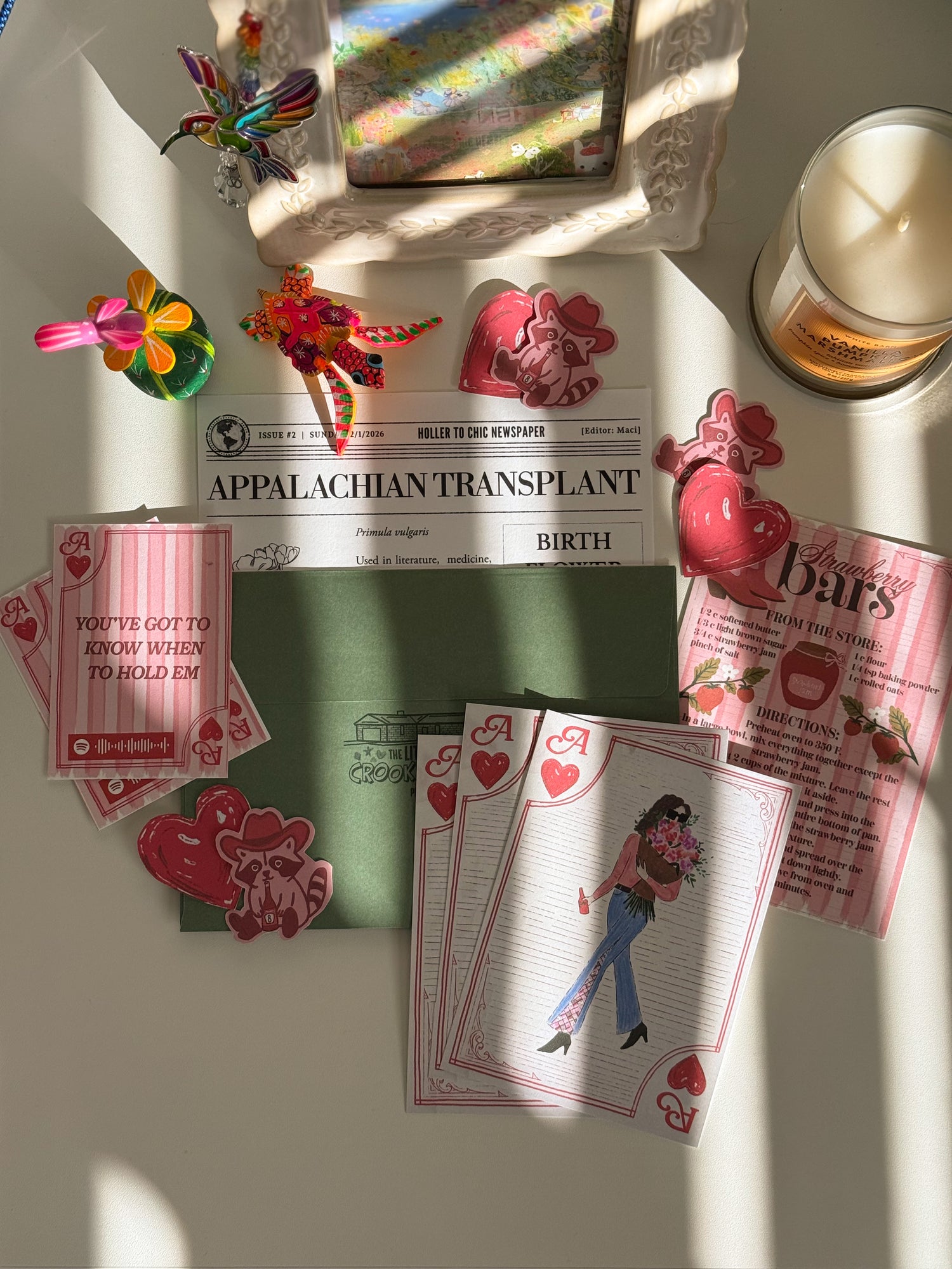 Collection of cards, and decorative items on a surface with 'Appalachian Transplant' magazine.